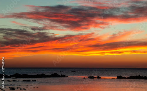 Orange sunset on sea with boats