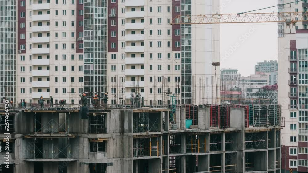 Constructors working at construction site residential estate building in city. Workers work with steel rebar concrete welder cloudy day Constructors working at construction site residential estate building in city. Workers work with steel rebar concrete welder cloudy day
