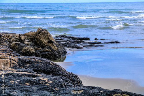 Rocky shoreline is waves swept, Murawai Beach, Auckland, New Zealand