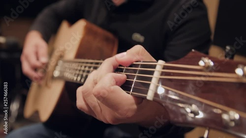 A man is playing his acoustic guitar. 4K and half speed slow motion.