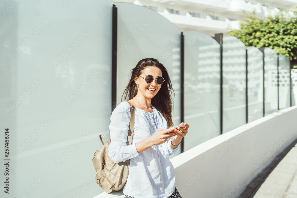 Pretty brunette girl outdoor using smart phone. Pretty brunette girl outdoor using smart phone.