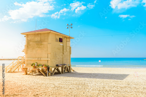 Yellow lifeguard tower at sandyTel Aviv Beach, Israel, against blue horizon. Summer, baywatch, vacation and travel concept.  photo