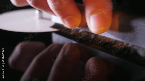 A man is cleaning a vinyl record with an antistatic brush. Close Up, and half speed slow motion. photo