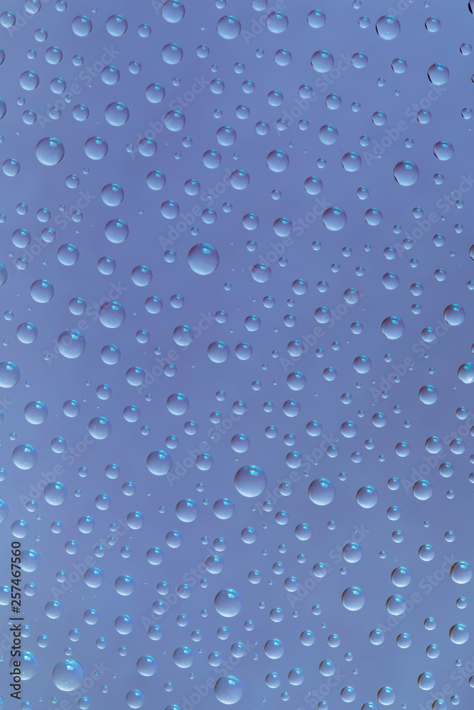 Beautiful water drops of the correct form on a gentle  blue background