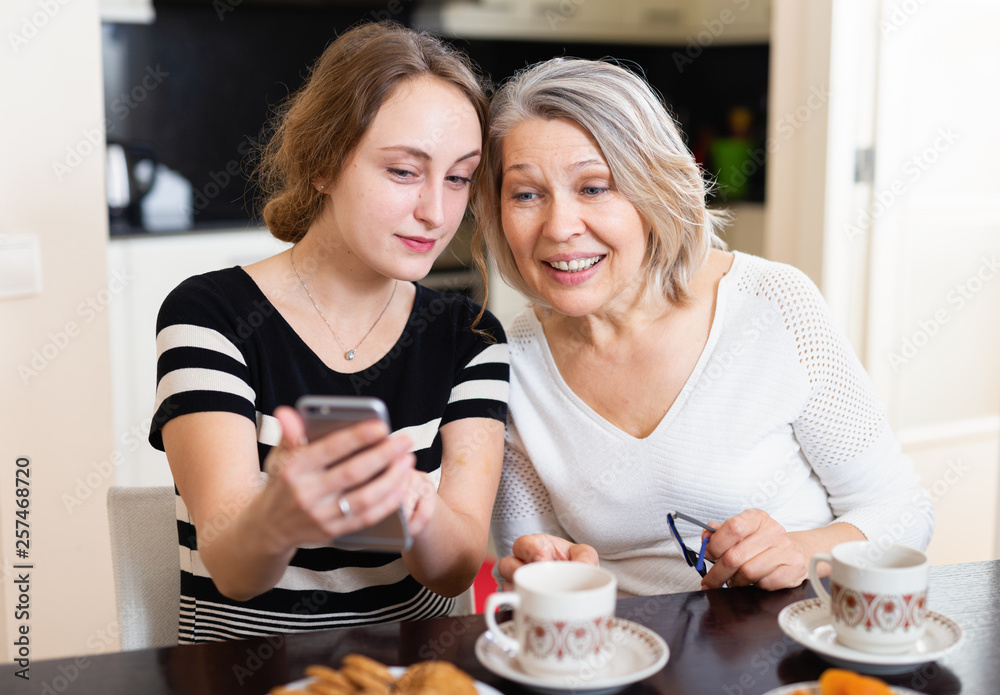 Mother with daughter using smartphone
