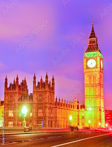 View of the Houses of Parliament and Westminster Bridge along River Thames in London at dusk.