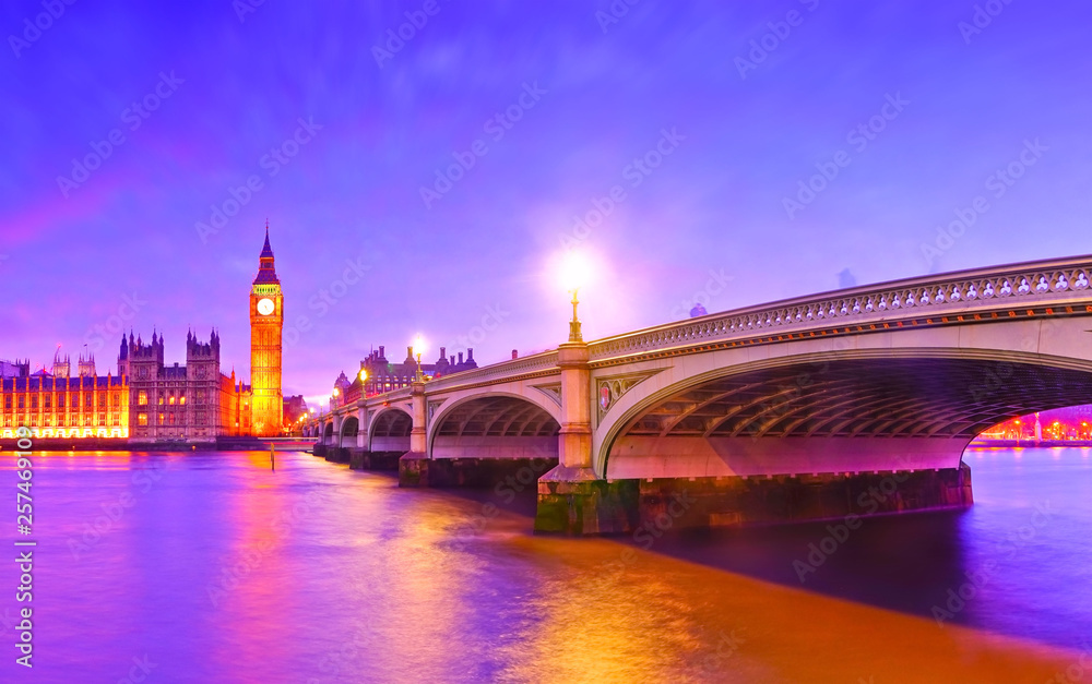 Fototapeta premium View of the Houses of Parliament and Westminster Bridge along River Thames in London at dusk.