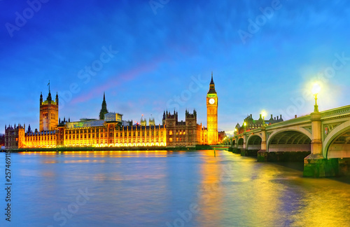 View of the Houses of Parliament and Westminster Bridge along River Thames in London at night. © Javen