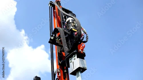 Pillar driving of hydraulic drilling or hammer machines on construction site. Worker operate pillars machine. Building solar power station.