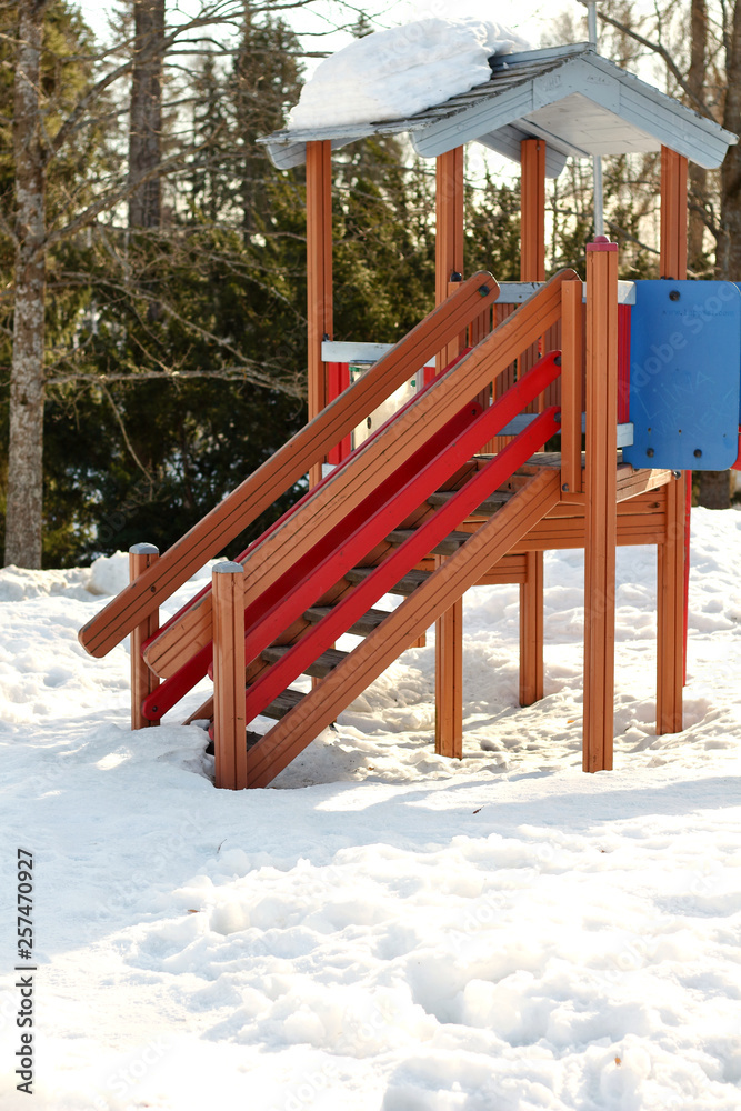 Colorful wooden empty nobody children's playground with a slide for activity childrens play in the winter on the snow Colorful wooden empty nobody children's playground with a slide for activity childrens play in the winter on the snow