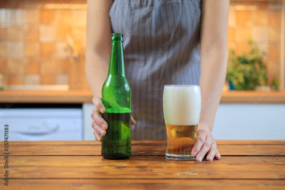 Woman holding green bottle beer and glass with beer Woman holding green bottle beer and glass with beer