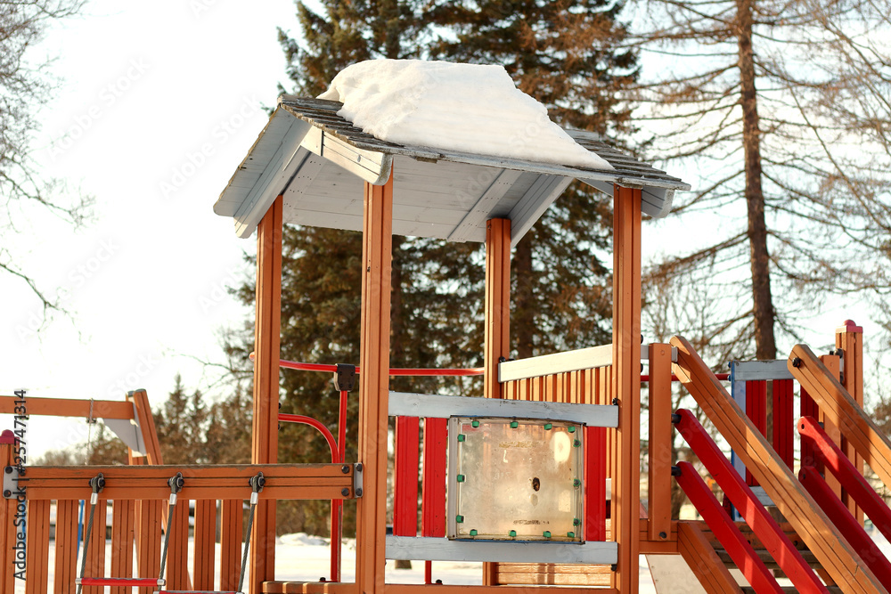 Colorful wooden empty nobody children's playground with a slide for activity childrens play in the winter on the snow Colorful wooden empty nobody children's playground with a slide for activity childrens play in the winter on the snow