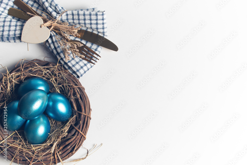 easter eggs blue on background with spoon and fork and dried grass with wood vine and flower easter eggs blue on background with spoon and fork and dried grass with wood vine and flower