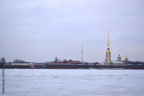 Saint Petersburg, Russia - March 17 2019: The view of the Peter and Paul Fortress and frozen Neva river from the embankment on a cloudy day