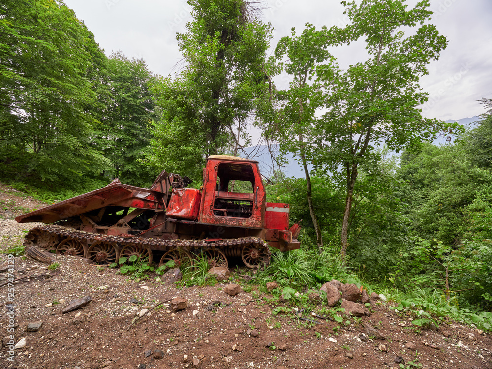 Abandoned snowcat on the ski slope in summer Abandoned snowcat on the ski slope in summer