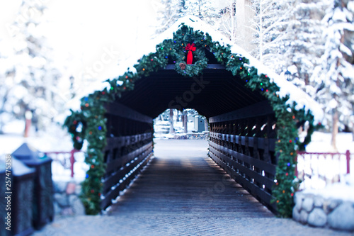 A athletic skier walking into a snowy covered walkway leading into Vail Village in Vail, Colorado. photo