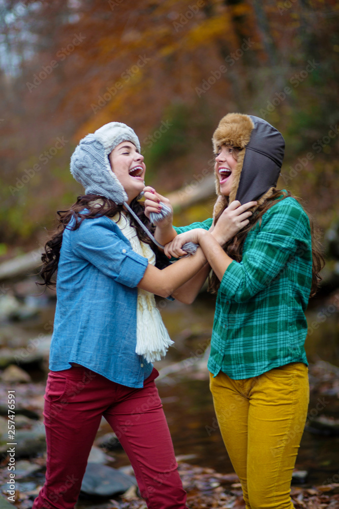 Two young women laugh while holding each other and walking down a riverbed near Lake Chinnabee Alabama. Two young women laugh while holding each other and walking down a riverbed near Lake Chinnabee Alabama.