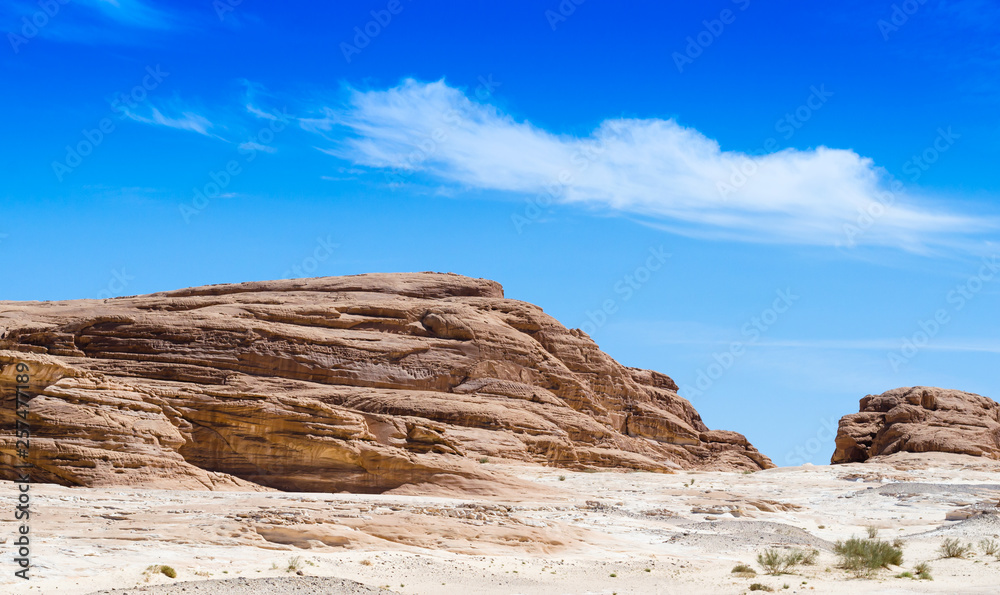 high rocky mountains against the blue sky and white clouds in the desert in Egypt Dahab South Sinai