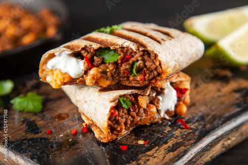 Mexican burrito with beef, beans and sour cream photo