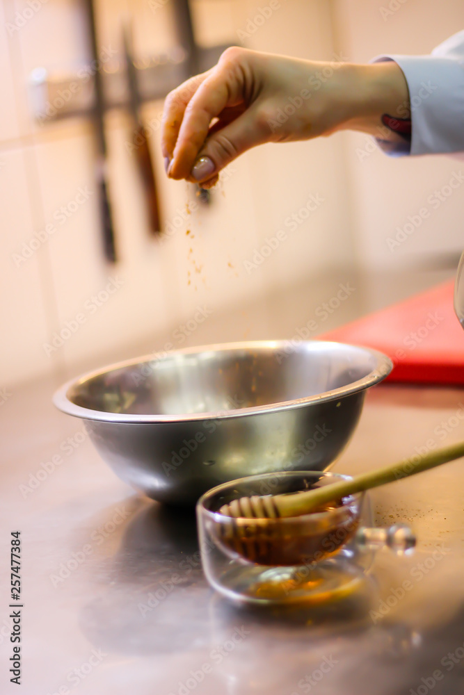 The chef cooking chicken wings in a sauce in the kitchen. Decorating the dishes with colored blobs. Lymon. Chicken. Sauce with honey and seasonings The chef cooking chicken wings in a sauce in the kitchen. Decorating the dishes with colored blobs. Lymon. Chicken. Sauce with honey and seasonings