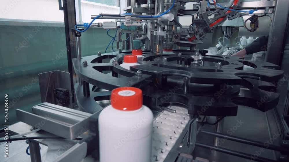 White plastic jars are getting mechanically closed with caps White plastic jars are getting mechanically closed with caps