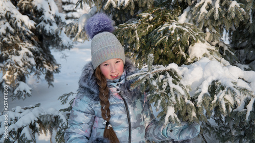 Girl in the Park in winter, snow and Christmas trees