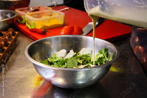 Chef cooking Caesar salad. Poached egg. Green. Sadat, Cheri tomatoes. Chestnut sauce. Decoration of plates. Fried bacon photo