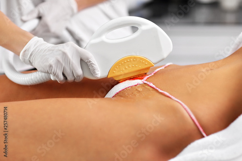 Beautician Giving Epilation Laser Treatment To Woman On Bikini
