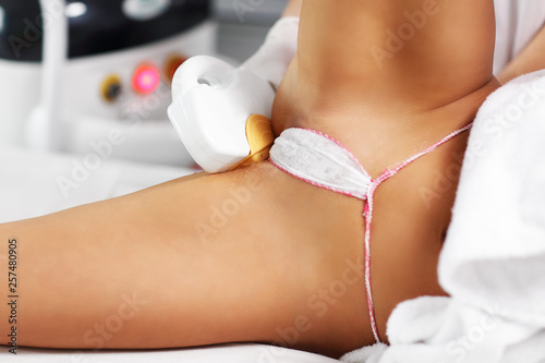 Beautician Giving Epilation Laser Treatment To Woman On Bikini photo