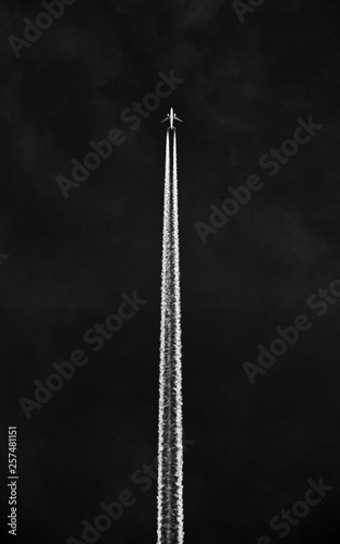 A passenger plane fly's through the air leaving a jet stream.