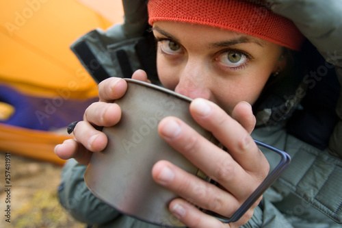 Woman sipping hot beverage during camping trip