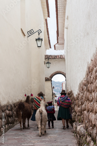 Native people and their llamas walking the streets of downtown Cusco, Perú