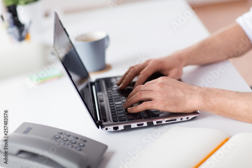 business, people and technology concept - hands typing on laptop computer keyboard at office