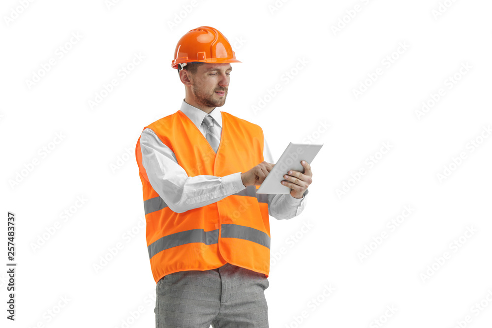 © master1305 - The builder in a construction vest and an orange helmet with tablet. Safety specialist, engineer, industry, architecture, manager, occupation, businessman, job concept © master1305 - The builder in a construction vest and an orange helmet with tablet. Safety specialist, engineer, industry, architecture, manager, occupation, businessman, job concept