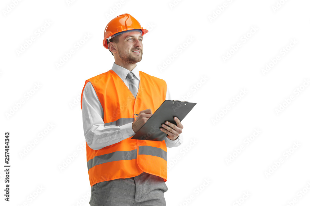 The builder in a construction vest and orange helmet standing on white studio background. Safety specialist, engineer, industry, architecture, manager, occupation, businessman, job concept The builder in a construction vest and orange helmet standing on white studio background. Safety specialist, engineer, industry, architecture, manager, occupation, businessman, job concept