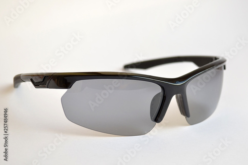 Obraz na plátně Sport black sunglasses with photochromic and polarizing effect on white backgrou