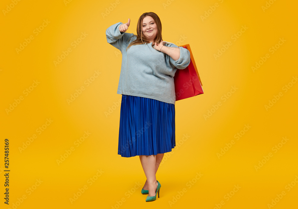 Plus size woman with paper bags gesturing thumb up Plus size woman with paper bags gesturing thumb up