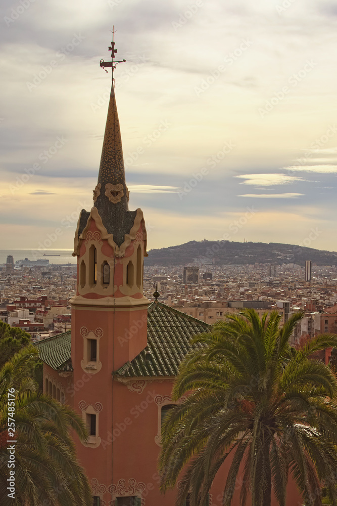 Stunning house with tower in Park Guell in cloudy day. Famous touristic place and travel destination in Barcelona, Spain, Europe Stunning house with tower in Park Guell in cloudy day. Famous touristic place and travel destination in Barcelona, Spain, Europe