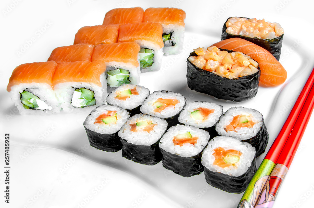 close up of sashimi sushi set, roll on white plate with chopsticks close up of sashimi sushi set, roll on white plate with chopsticks