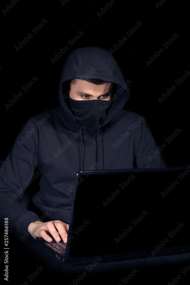 Hacker with laptop initiating cyber attack, isolated on black Hacker with laptop initiating cyber attack, isolated on black