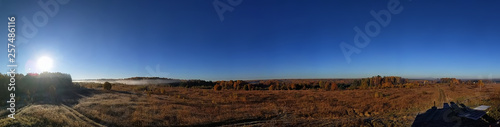 Amazing panorama of the rural autumn landscape of a European village with a colorful sky and an infinite golden field.