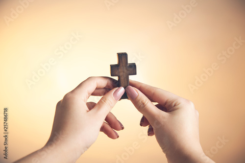 woman hand holding wooden cross