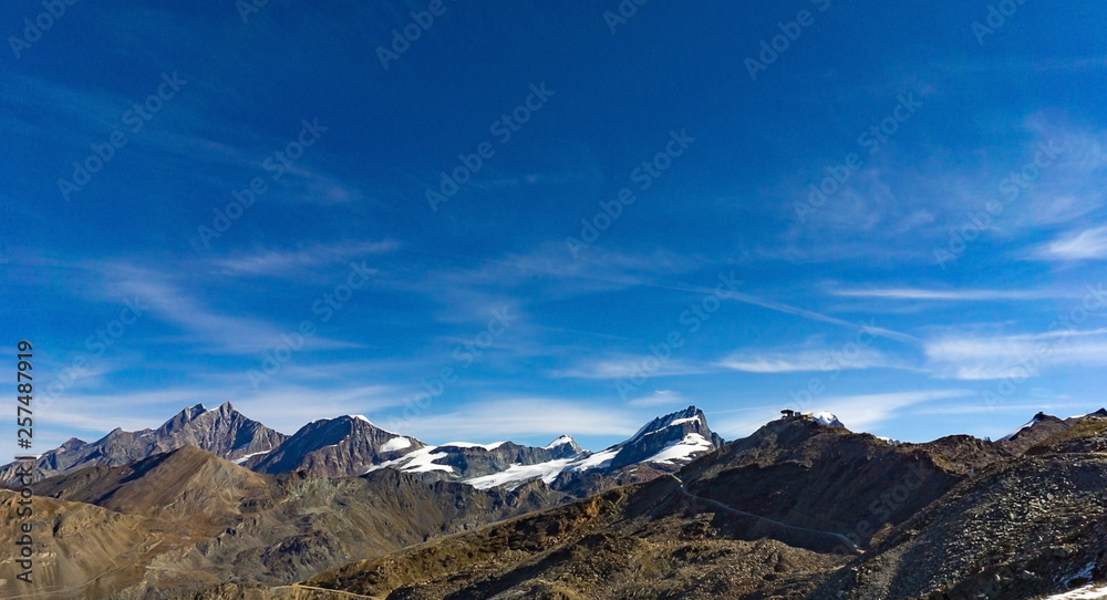 Landscape of snow capped mountain range in cloud blue sky day