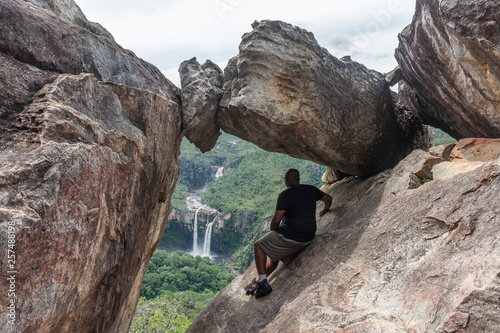 Hiker sitting on rock formation, Mirante da Janela, Chapada dos Veadeiros, Goias, Brazil photo