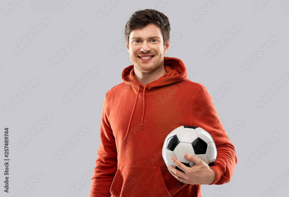 sport, leisure games and people - happy man or football fan in red hoodie with soccer ball over grey background sport, leisure games and people - happy man or football fan in red hoodie with soccer ball over grey background