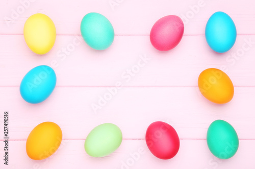 Colorful easter eggs on pink wooden table