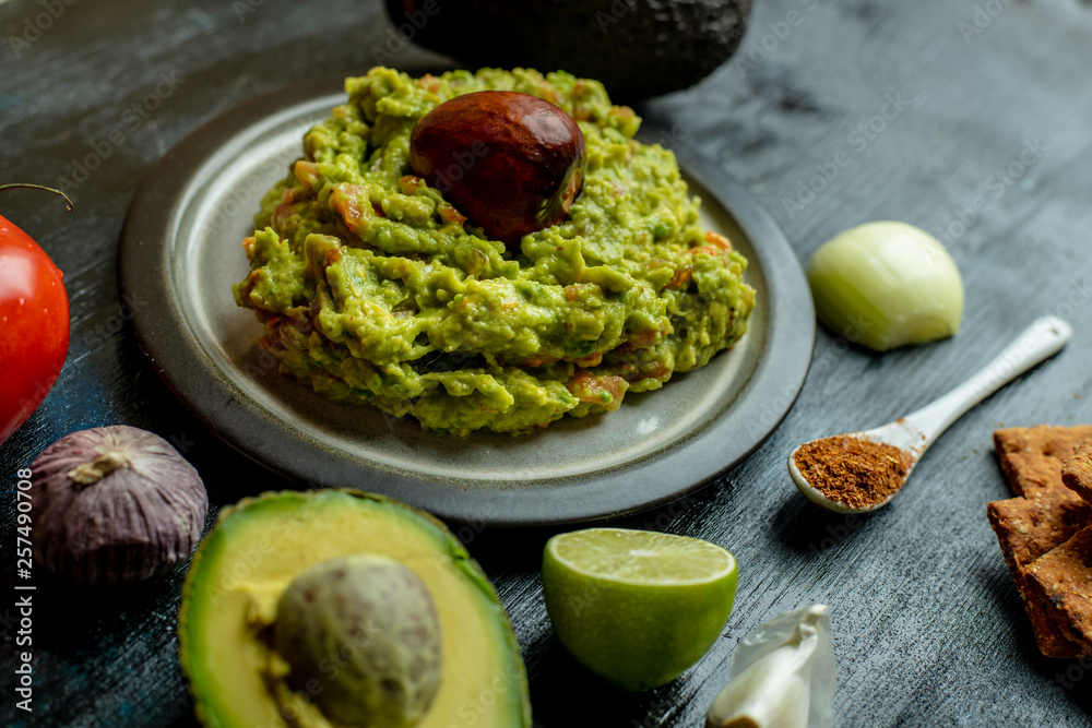 green, naturally made traditional guacamole surrounded by fresh ingredients and nachos green, naturally made traditional guacamole surrounded by fresh ingredients and nachos