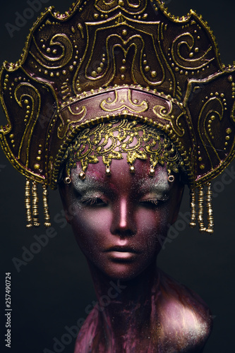 Head of mannequin in decorated bronze kokoshnick, dark studio background