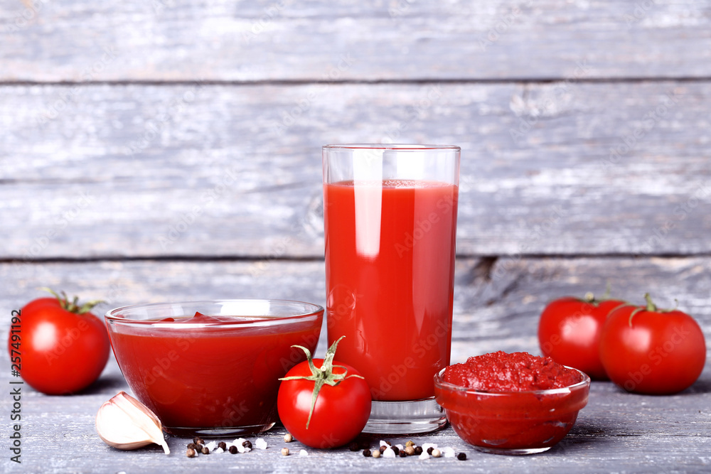 Tomato juice in glass with ketchup and garlic on wooden table Tomato juice in glass with ketchup and garlic on wooden table