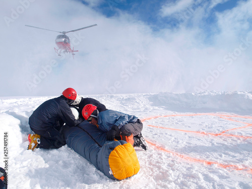 Mountain Rescuers are protecting a victim for the down wind of the landing helicopter at 14.000 foot on Denali, formerly known as Mount McKinley.  photo